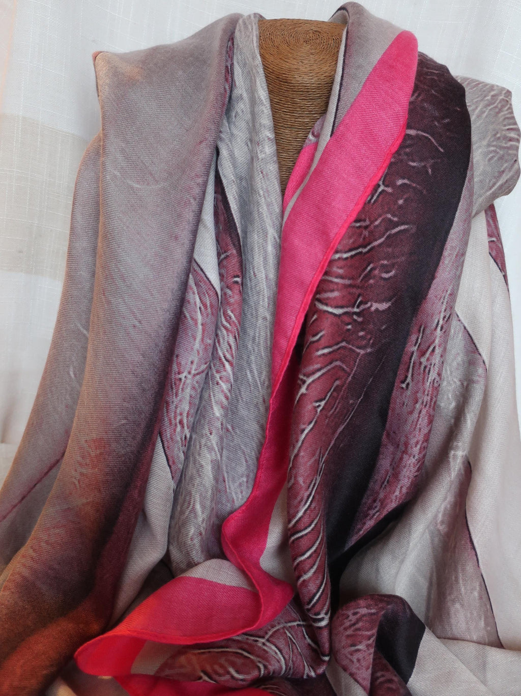 Multicolored scarf draped over a mannequin against a neutral background
