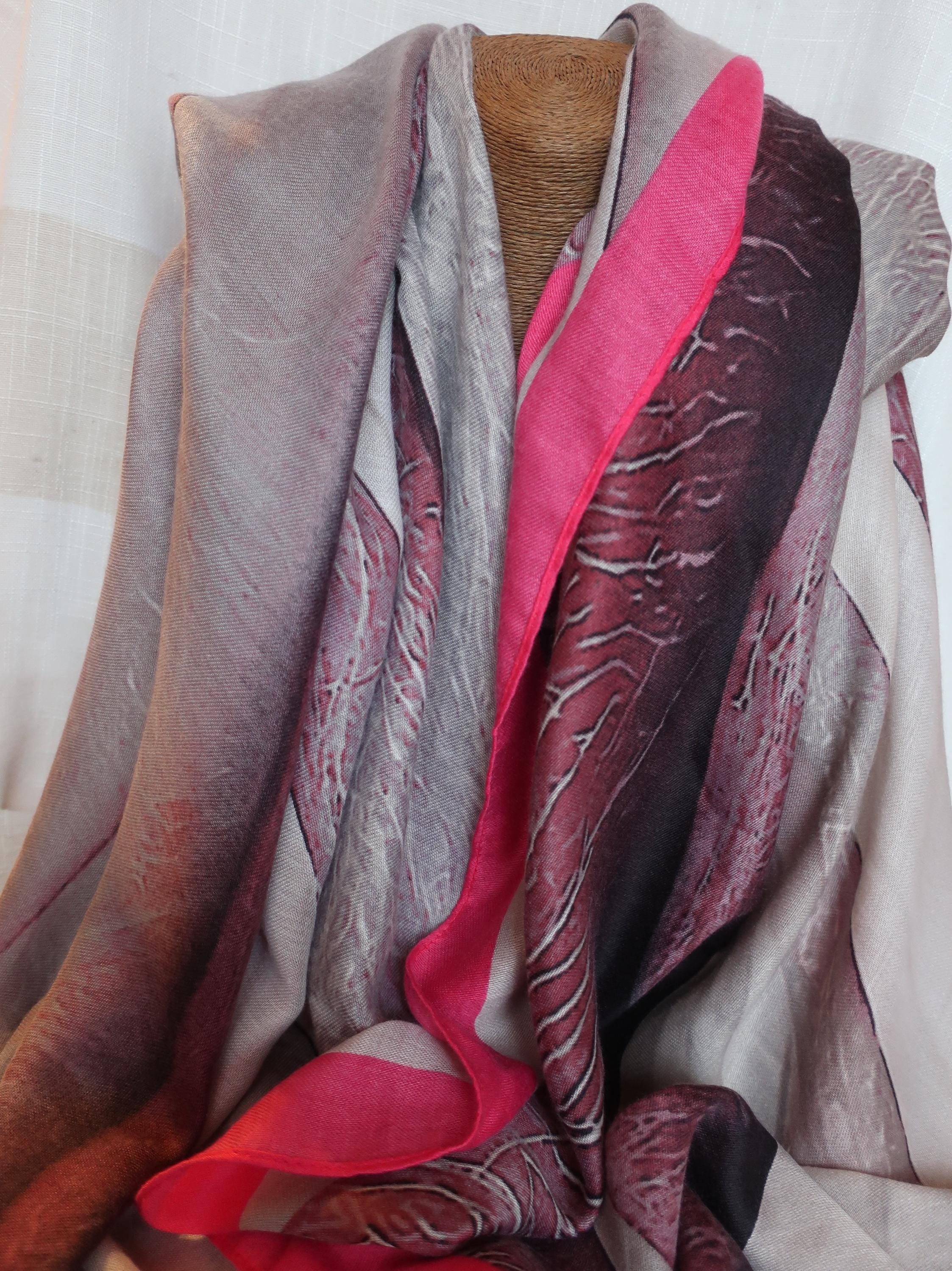 Multicolored scarf draped over a mannequin against a neutral background