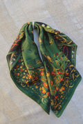 Green scarf with floral pattern on a beige fabric background