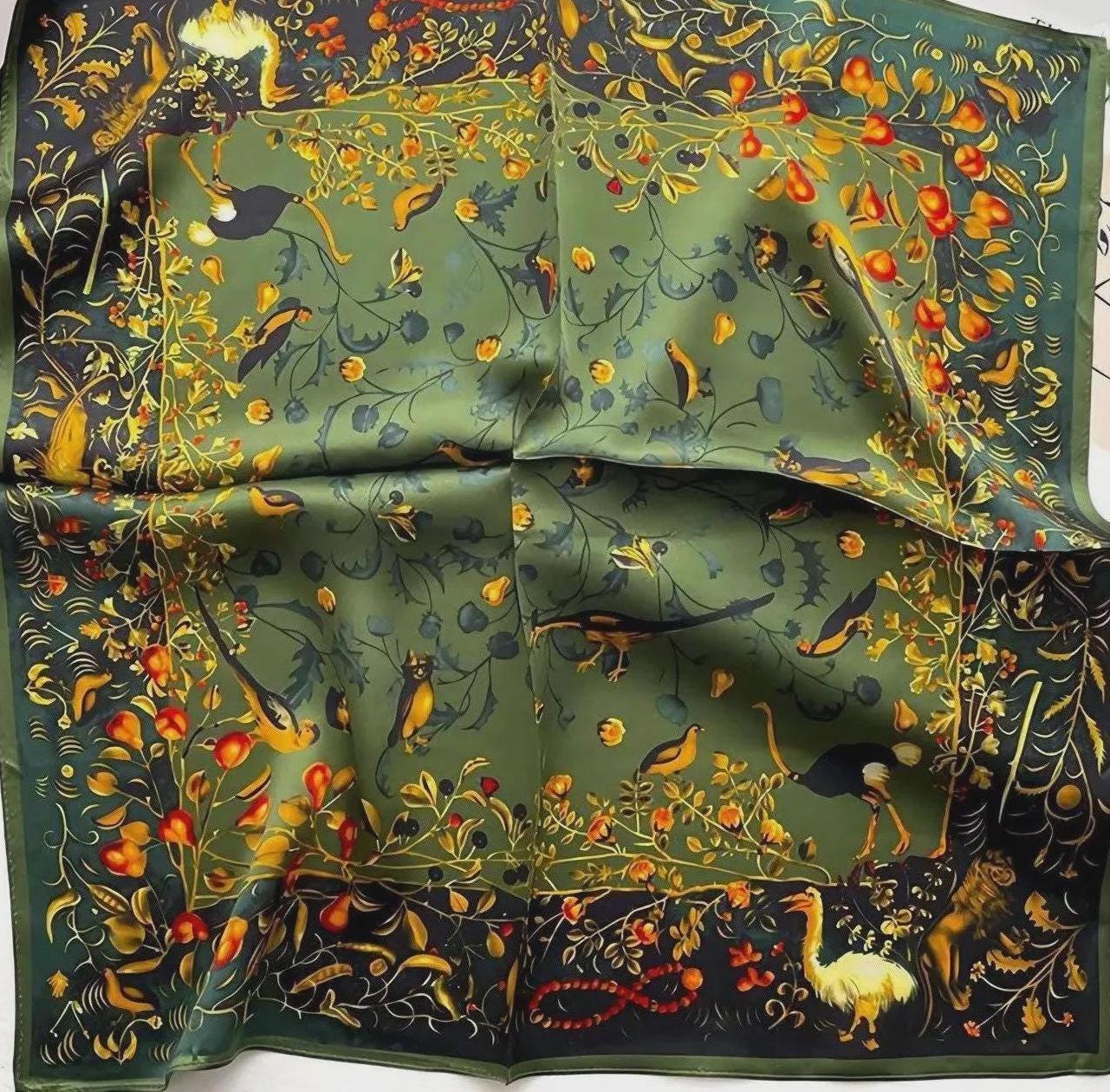 Decorative fabric with intricate patterns of birds, flowers, and animals on a green background.