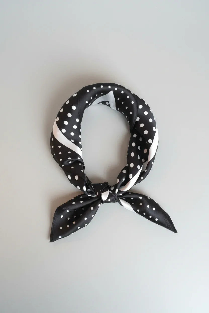 Black and white polka dot scarf on a light gray background