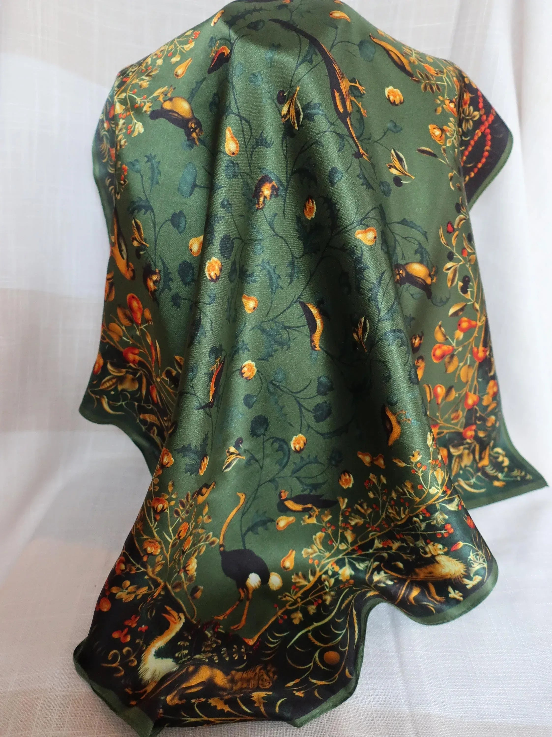 Green fabric with nature-themed design on a white background