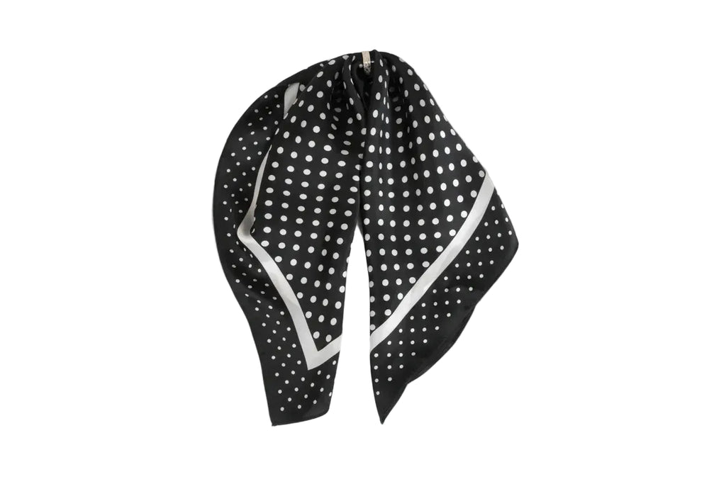 Black and white polka dot headscarf on a light gray background