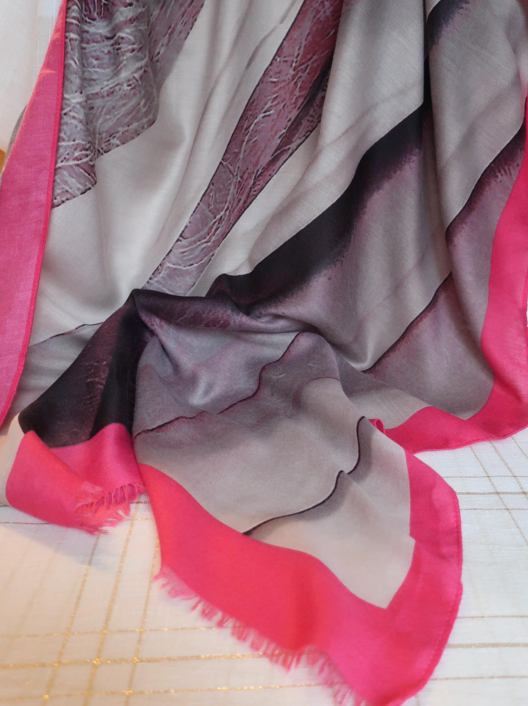 Close-up of a fabric with red, gray, and pink colors on a tiled floor background.